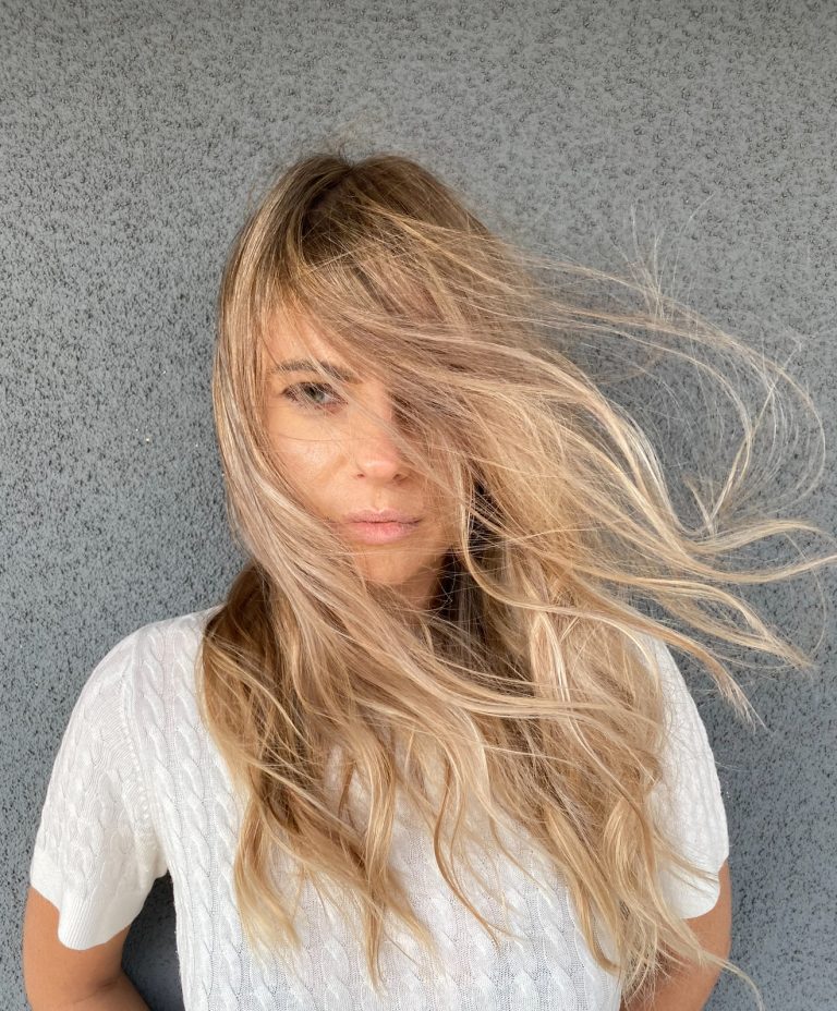 Long, blonde, balayaged hair blowing in the wind